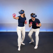 Couple wearing VR headsets playing with controllers in a padded room, VR experience gift