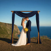 Newlyweds holding hands beneath an arch at a cliff's edge, Wedding & Elopement Packages experience gift