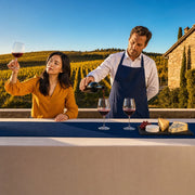 Sommelier pouring wine beside a slate cheese board on a vineyard terrace, Wine & Cheese Pairing experience gift