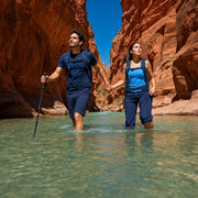 Couple wading hand in hand through a narrow sandstone canyon river, Zion National Park Tour experience gift